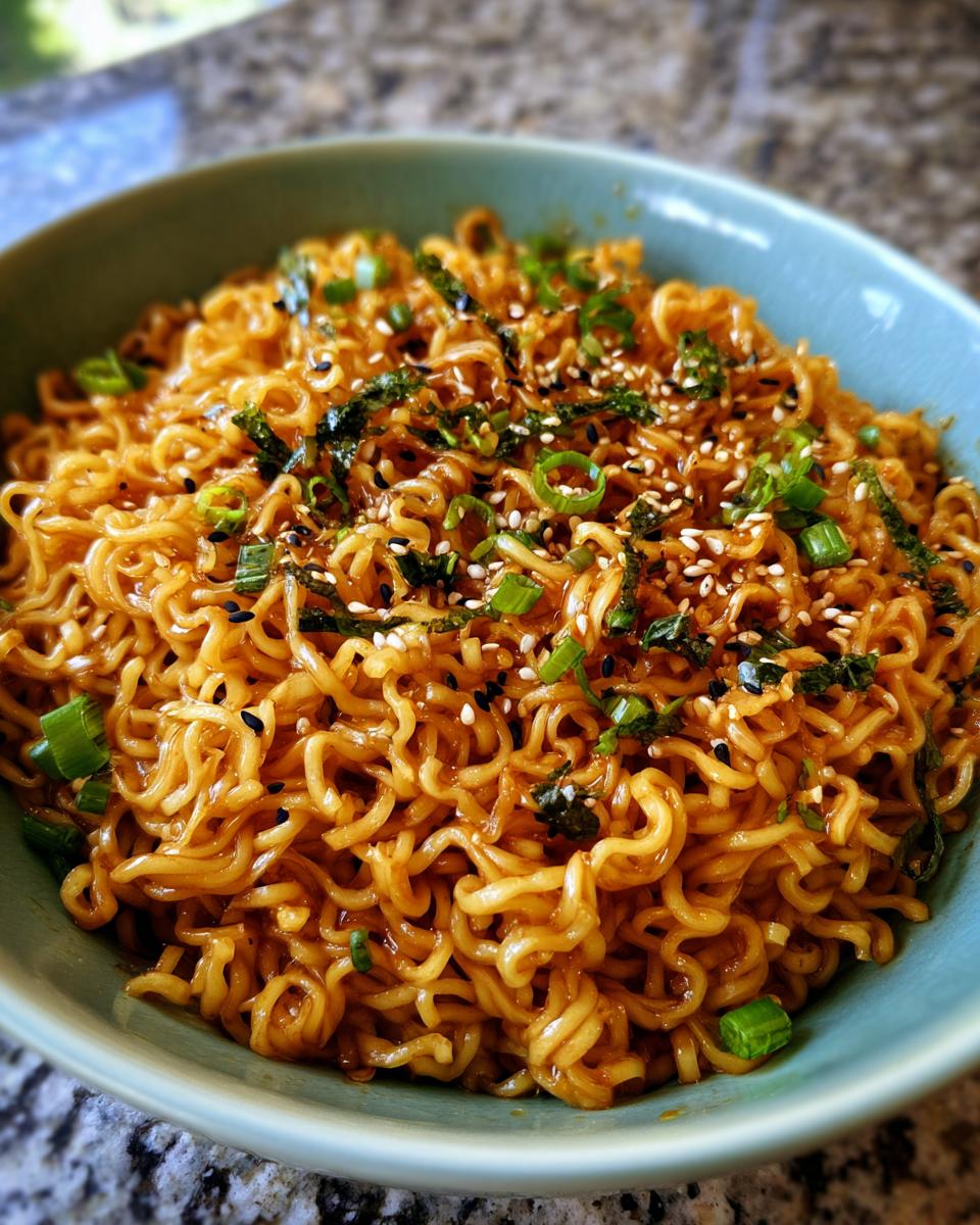 Close-up of a bowl of 3-Ingredient Ramen Stir-Fry, garnished with sesame seeds and green onions.