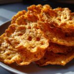Close-up of golden brown Baked Apple Cinnamon Oat Chips on a plate.