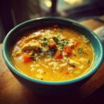 Close-up of a bowl of delicious Chicken & Rice Comfort Soup with chicken, rice, and carrots.