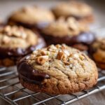 Close-up of a Chocolate-Dipped Toffee Almond Cookie, showing the chocolate dip and almond topping.