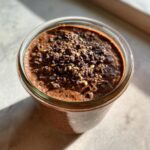 Close-up of Chocolate Protein Overnight Oats in a glass jar, topped with chocolate chips.