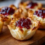 Close-up of a Cranberry Brie Phyllo Cup, showing flaky pastry filled with melted brie and topped with cranberry sauce.