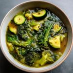 Overhead shot of a bowl of Detox Green Vegetable Soup with broccoli, zucchini, and kale.