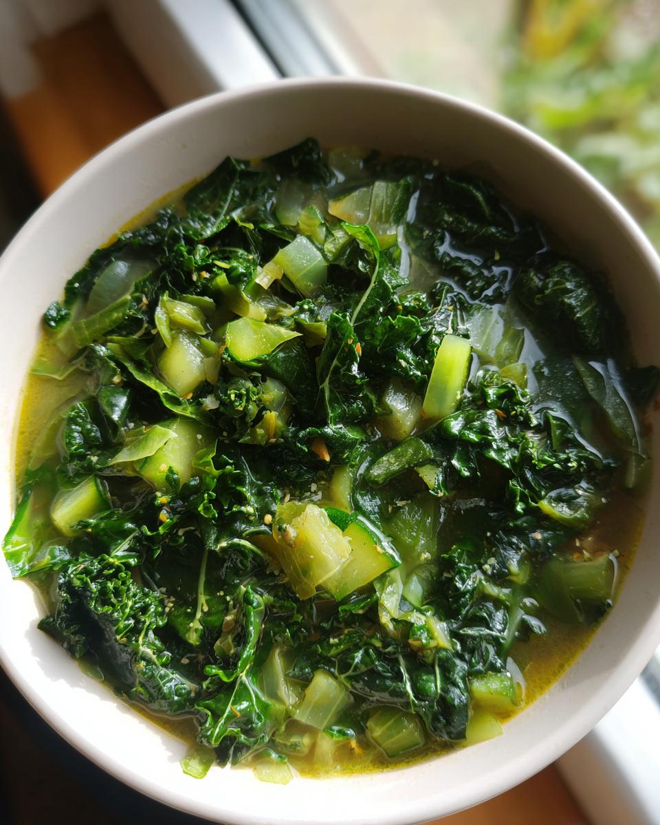 Close-up of a bowl of Detox Green Vegetable Soup with kale and other green vegetables.