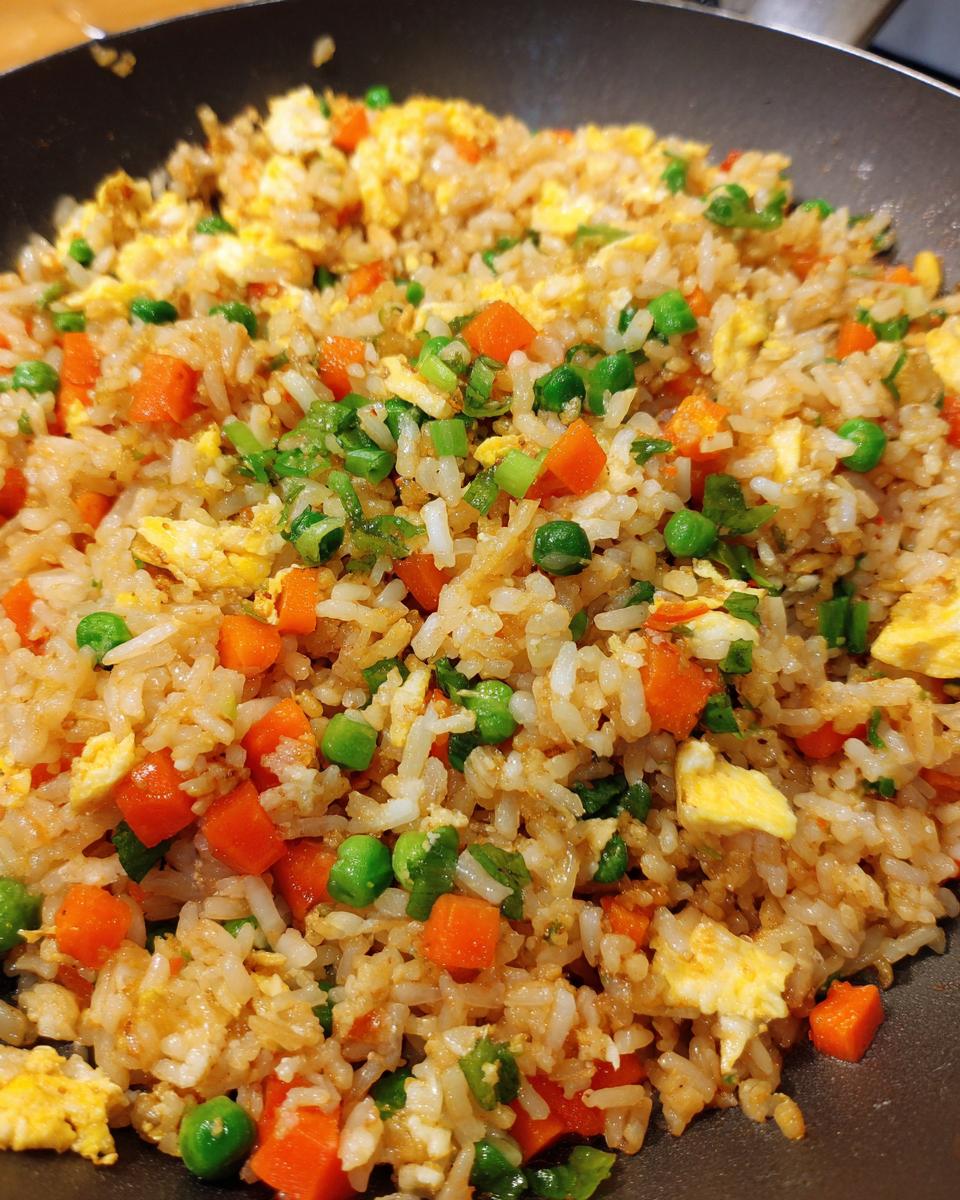 Close-up of Easy Veggie Fried Rice with Egg in a pan, with carrots, peas, and egg.