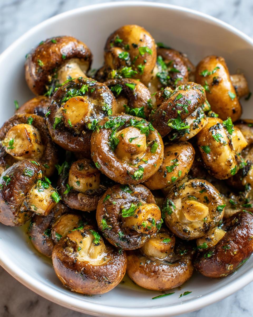 Close-up of Garlic Butter Mushrooms in a white bowl, garnished with parsley.