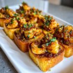 Close-up of Garlic Butter Shrimp Toasts for Appetizers, featuring golden-brown bread topped with succulent shrimp in a glistening sauce and fresh herbs.