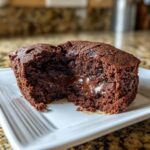 Close-up of a Greek Yogurt Chocolate Peanut Butter Mug Cake cut open, revealing a molten chocolate center.