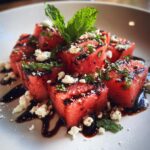 Close-up of a Grilled Watermelon Feta Salad with feta cheese, mint, and balsamic glaze.