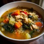 Close-up of a bowl filled with High-Protein Turkey & Quinoa Soup, with visible quinoa, turkey, and vegetables.