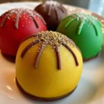 Close-up of colorful Holiday Ornament Oreo Truffles, decorated with sprinkles and chocolate.