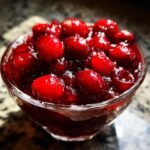Close-up of a glass bowl filled with vibrant Homemade Cranberry Sauce, perfect for the holidays.