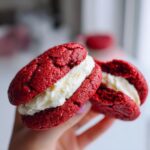 Close-up of Levain Bakery-Style Red Velvet Cookies with cream cheese filling, held in hand.