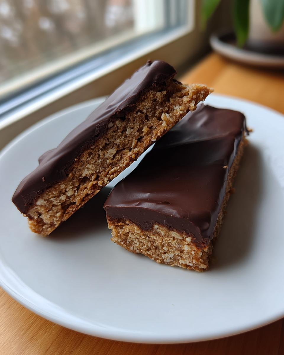Close-up of North Pole Chocolate-Dipped Shortbread Bars on a white plate, showing the chocolate coating.