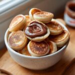 Close-up of a bowl filled with Nutella-Stuffed Pancake Cereal, a fun breakfast treat.