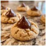 Close-up of Santa's Favorite Peanut Butter Blossoms cookies with chocolate kiss topping.