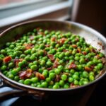 Close-up of a pan of delicious Peas with Pancetta, cooked to perfection.