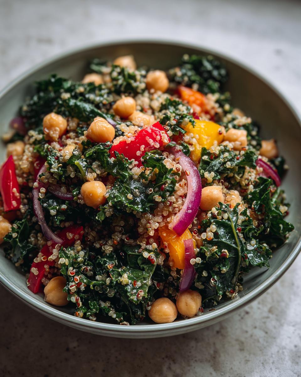 Close-up of a Quinoa Kale Power Bowl with chickpeas, red onion, and bell peppers.