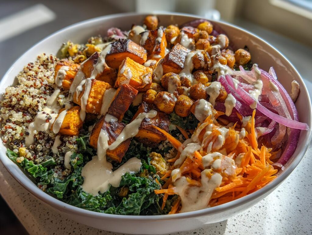 Close-up of a Spiced Chickpea and Sweet Potato Buddha Bowl with quinoa, kale, and tahini dressing.
