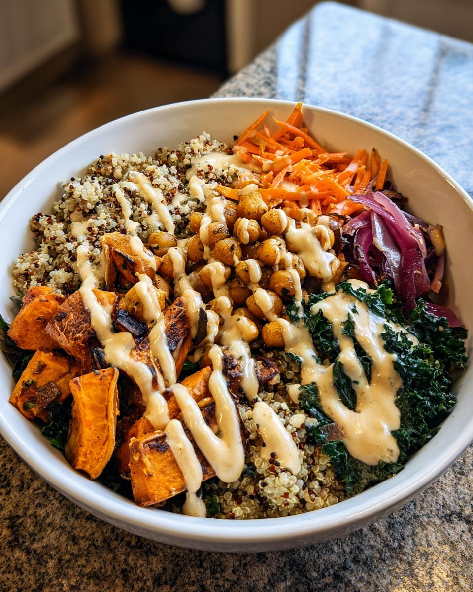 A vibrant Spiced Chickpea and Sweet Potato Buddha Bowl with quinoa, vegetables, and a creamy dressing.