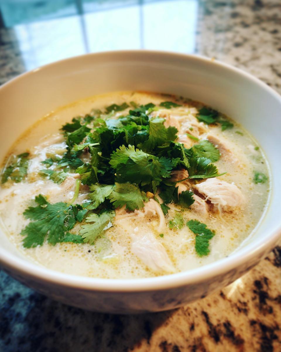 A bowl of creamy Thai-Inspired Coconut Chicken Soup garnished with fresh cilantro.