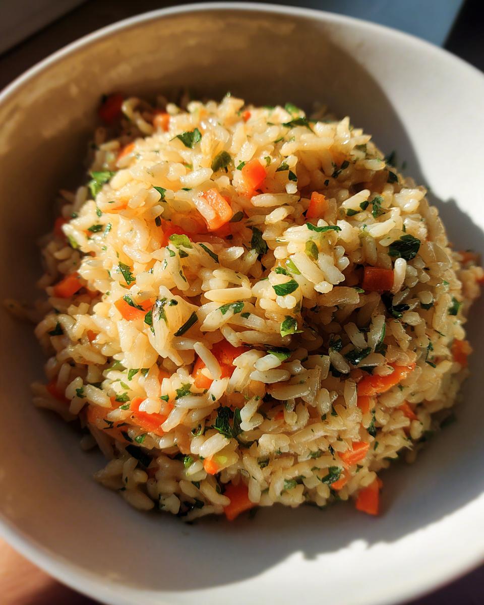 Close-up of a bowl filled with Wild Rice Pilaf, carrots, and herbs.
